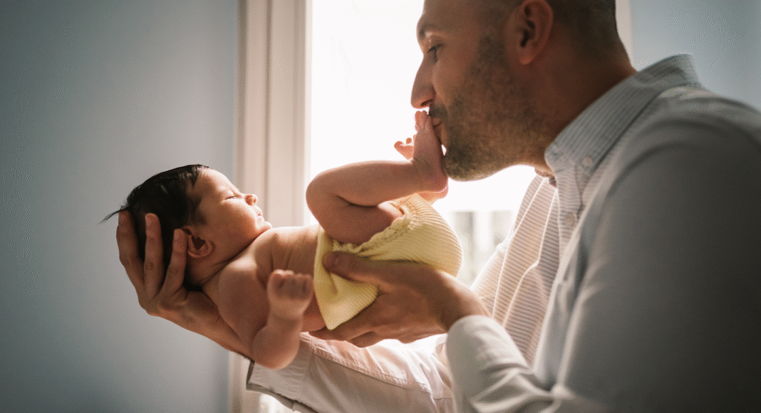 37-anos-depois-licenca-paternidade-sai-de-5-para-15-dias-no-brasil Pai segurando bebê recém-nascido, simbolizando a Licença Paternidade e o vínculo familiar.