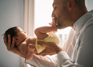 A Evolução da Licença Paternidade no Brasil: Um Comparativo Global e Seus Novos Benefícios para Pais Pai segurando bebê recém-nascido, simbolizando a Licença Paternidade e o vínculo familiar.