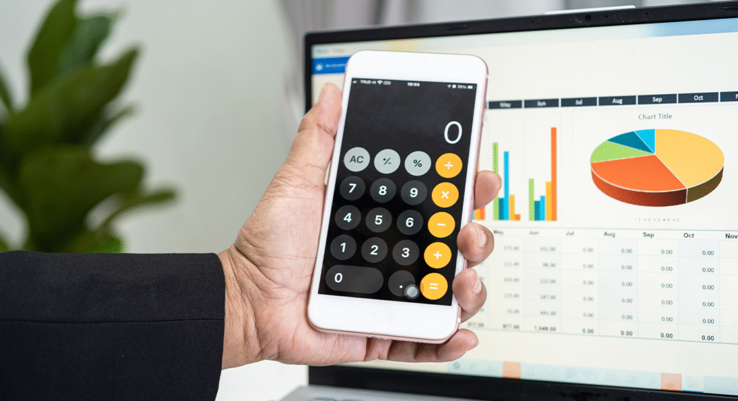 7-situacoes-que-a-calculadora-da-reforma-tributaria-se-torna-indispensavel-na-rotina Uma pessoa usando a calculadora da reforma em um computador, analisando dados financeiros.