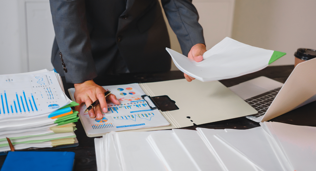 Simples Nacional na Reforma Tributária: um empresário analisa relatórios fiscais em seu computador, representando a necessidade de planejamento.