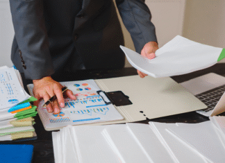 O Futuro do Simples Nacional: Como Pequenas Empresas Podem se Preparar para a Reforma Tributária Simples Nacional na Reforma Tributária: um empresário analisa relatórios fiscais em seu computador, representando a necessidade de planejamento.